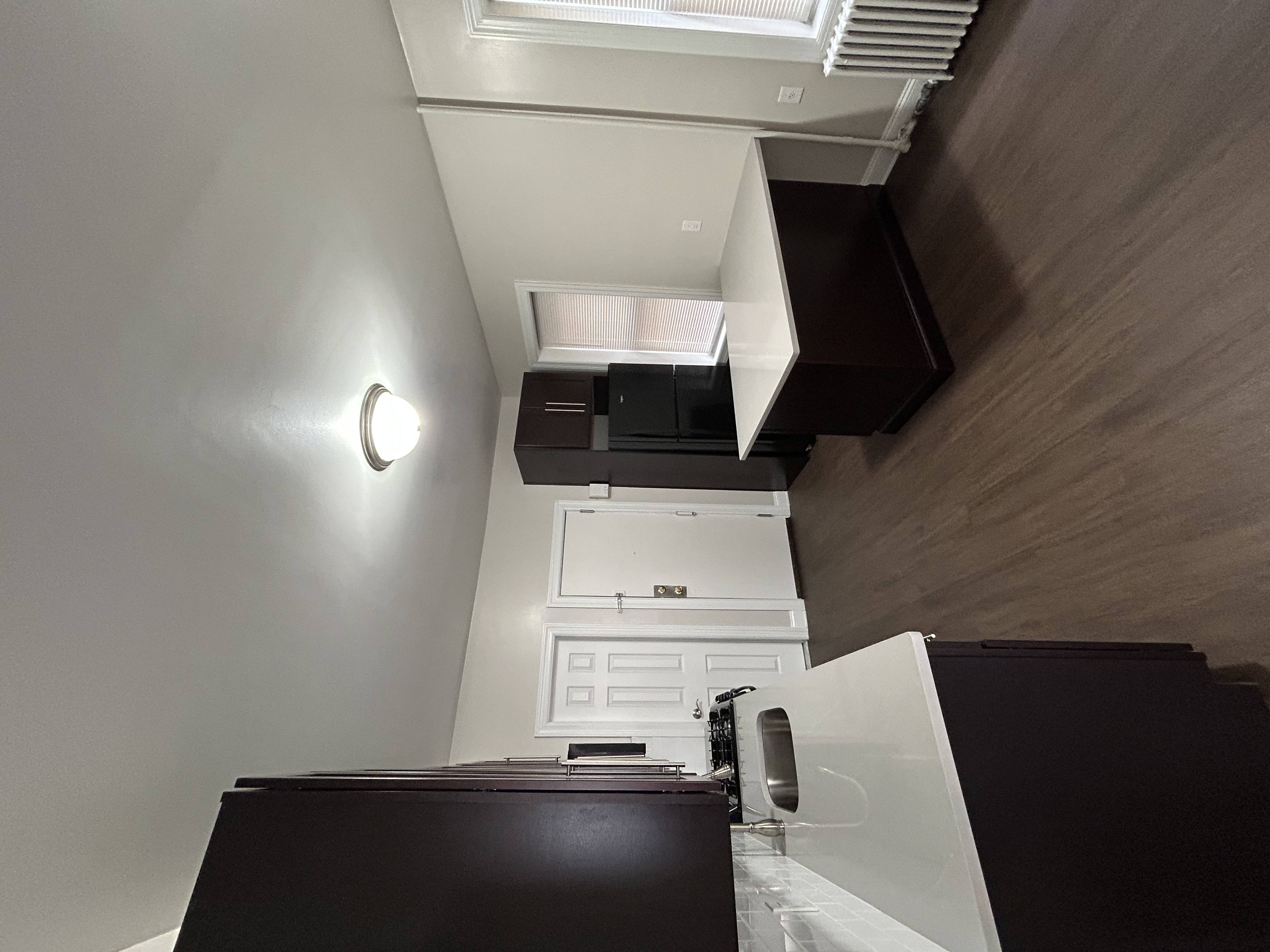 A white appliance is installed in a kitchen with dark brown cabinets.